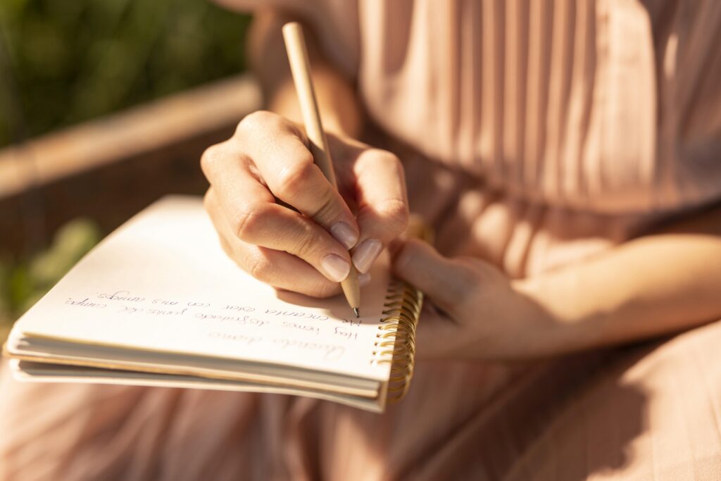 close-up-hand-writing-notebook