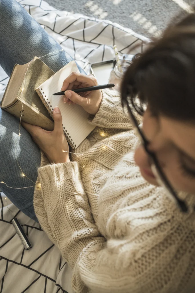 anonymous-lady-sitting-bed-making-notes