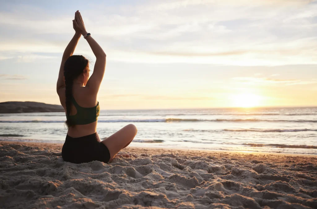 woman-yoga-meditation-beach-sunset-spiritual-wellness-zen-workout-outdoors-female-yogi-relaxing-meditating-sunrise-calm-peaceful-mind-awareness-by-ocean-coast